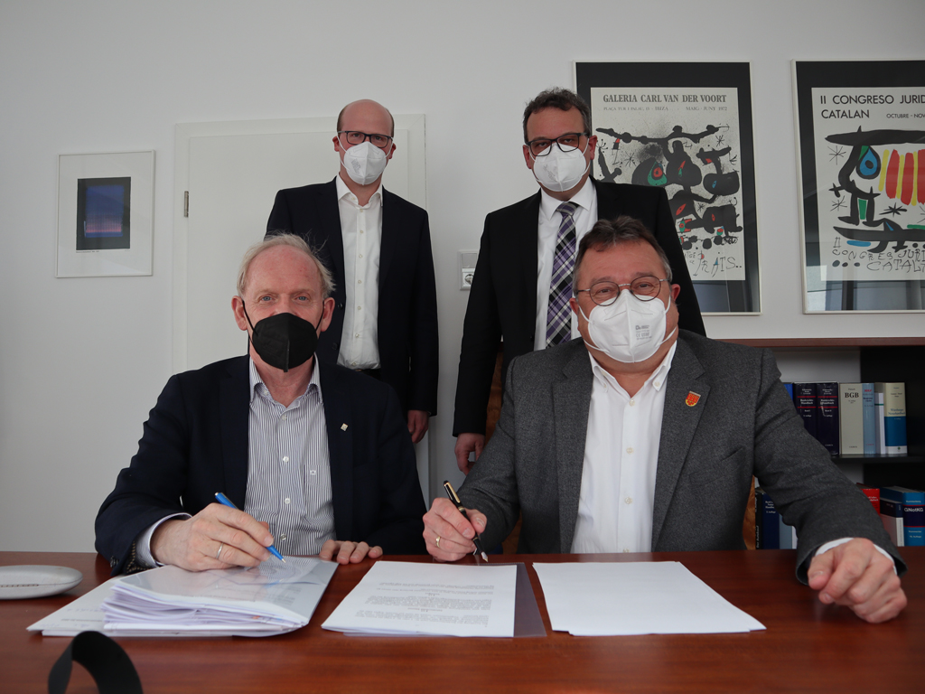 Foto hinten v. li.: Baudezernent Boris Krumtünger und Notar Dirk Funke sowie vorne v. li.: Reinhold Gierse von der Firma Heckmann Bauland und Wohnraum GmbH & Co.KG und Bürgermeister Christian Thegelkamp.